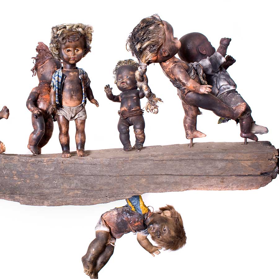 <strong>Gérard Quenum</strong>, <em>Clandestins (Stowaways)</em>, 2009.<br>
Wood, metal and plastic dolls, 151 x 405cm